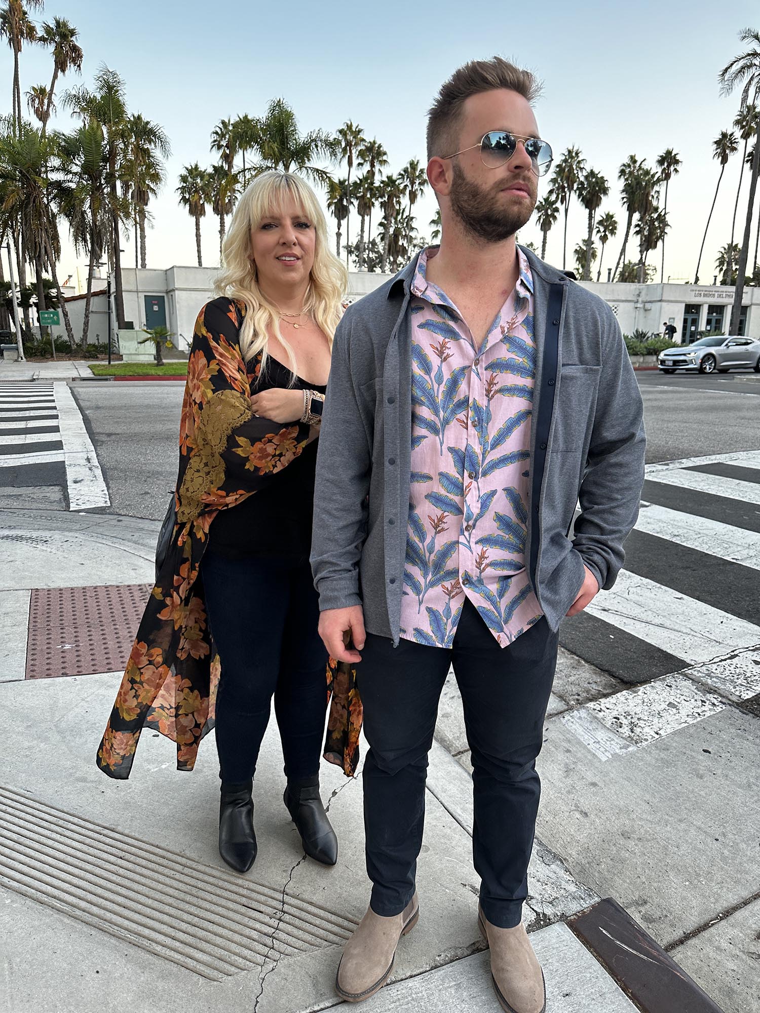 A photograph of a man and a woman stand on a street corner